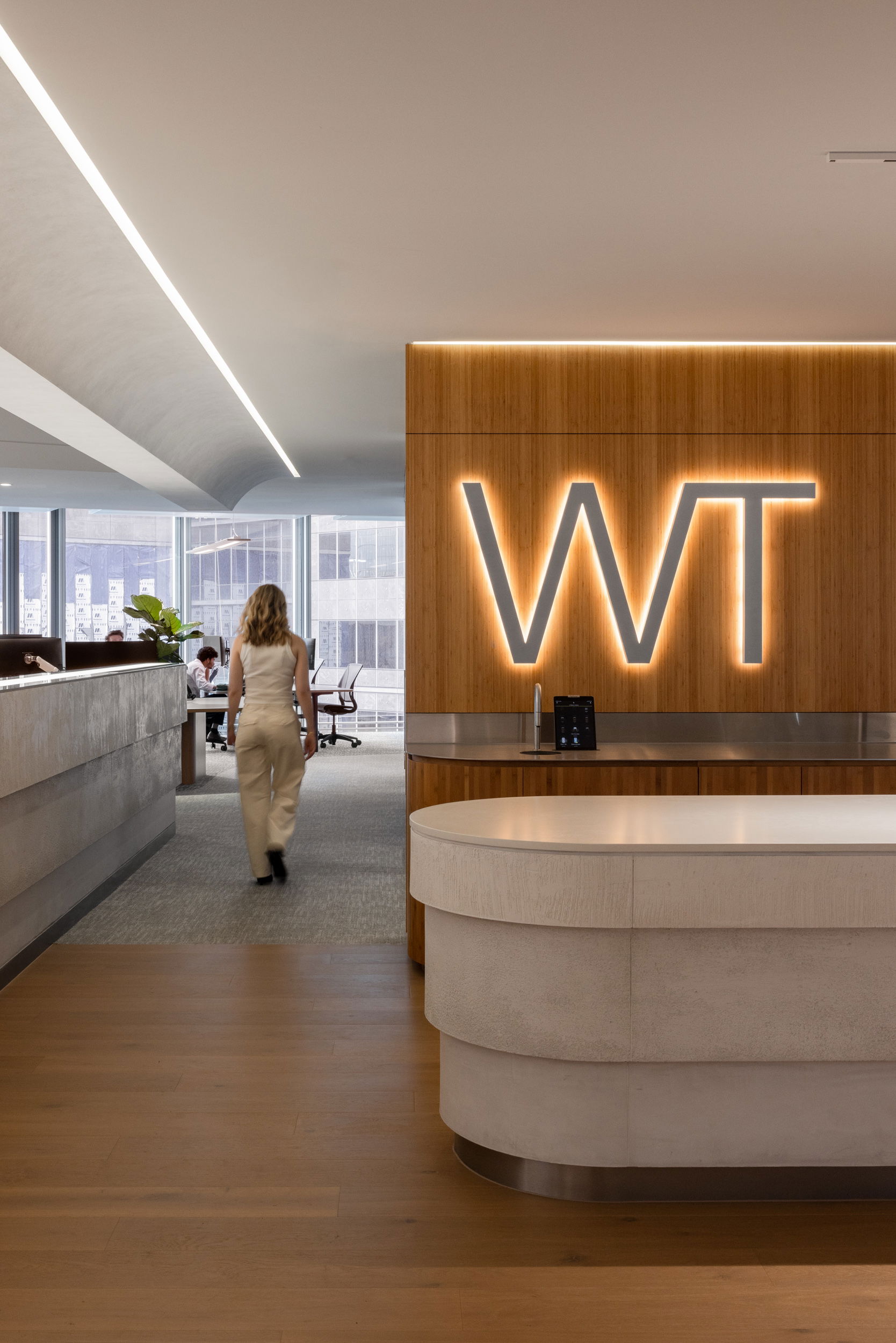 WT Sydney fitout. Breakout kitchen space with Engineered Bamboo and staff member walking past